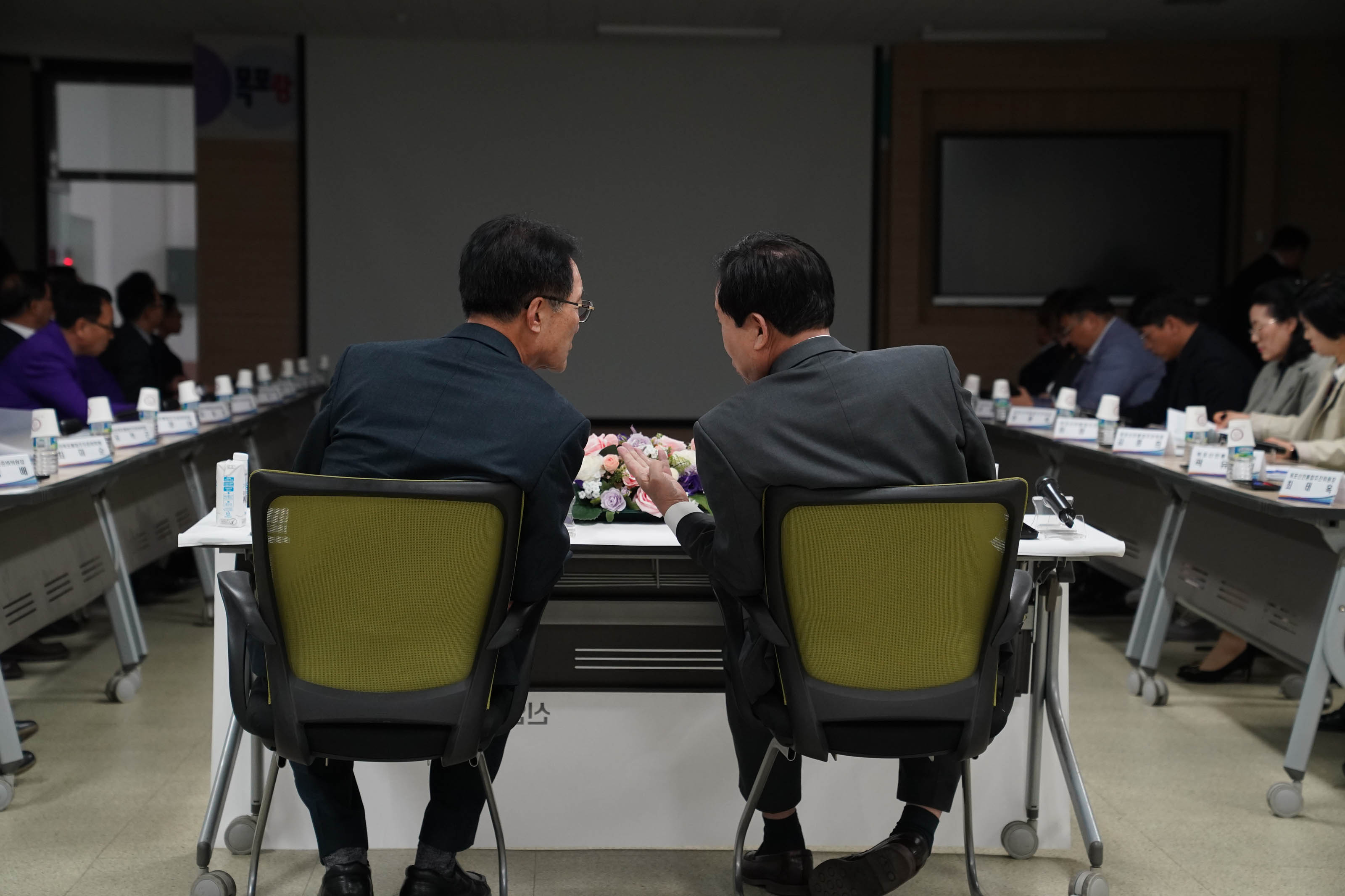 단상에 앉아 서로 대화하고있는 박홍률 시장과 박우량 군수 뒷모습