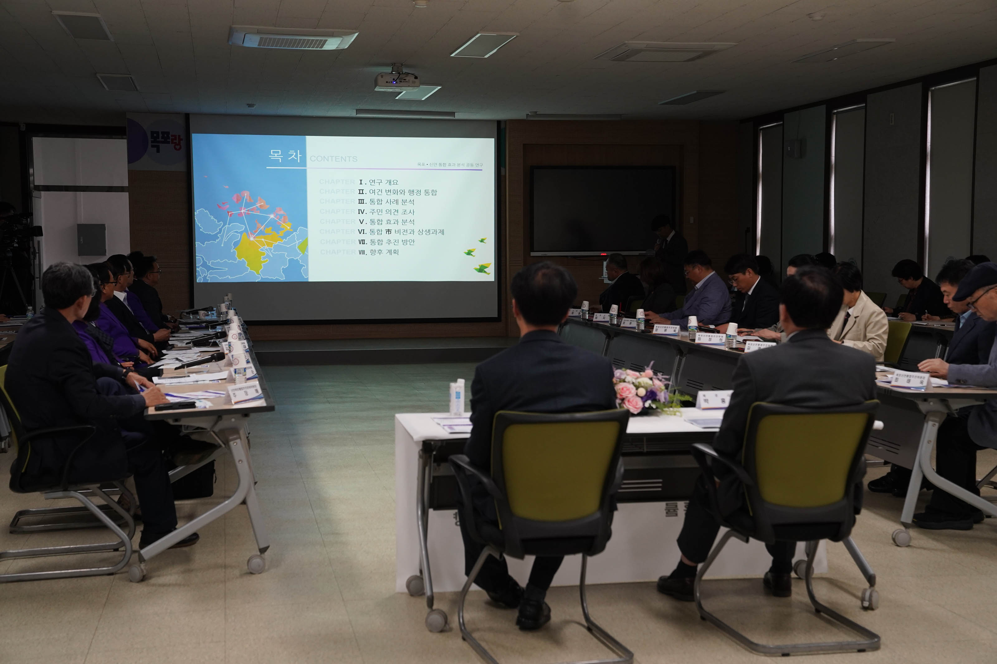 ppt 목차부분을 띄어놓고 다함께 보고있는 보고회 참석자들 박홍률 시장과 박우량 군수 뒤에서 찍은 사진.