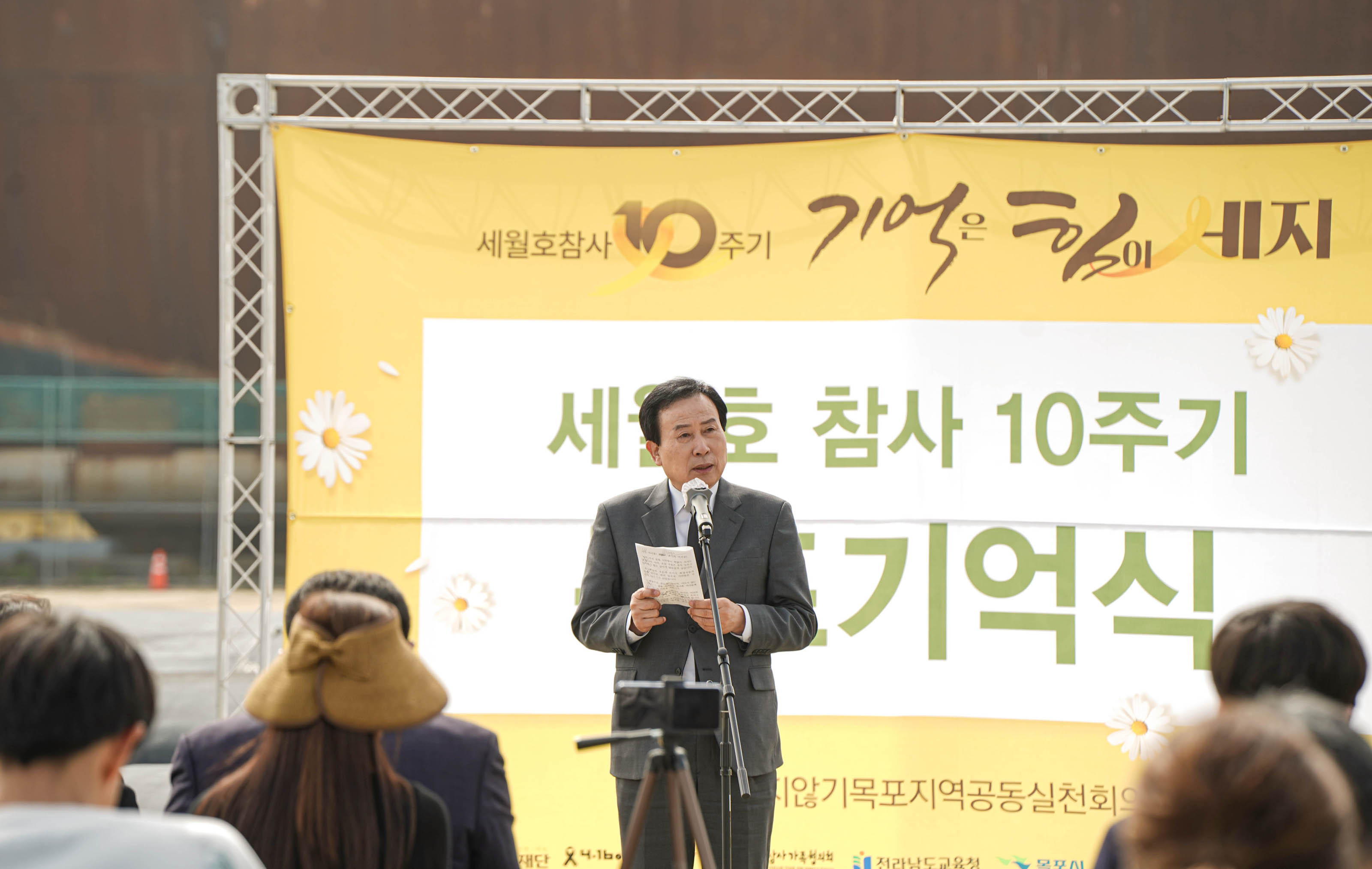 세월호 참사10주기 기억은 힘이 세지 세월호 참사 10주기 목포기억식 현수막을 배경으로 연설하고있는 시장 박홍률 근접사진 앉아서 경청하는 청중들
