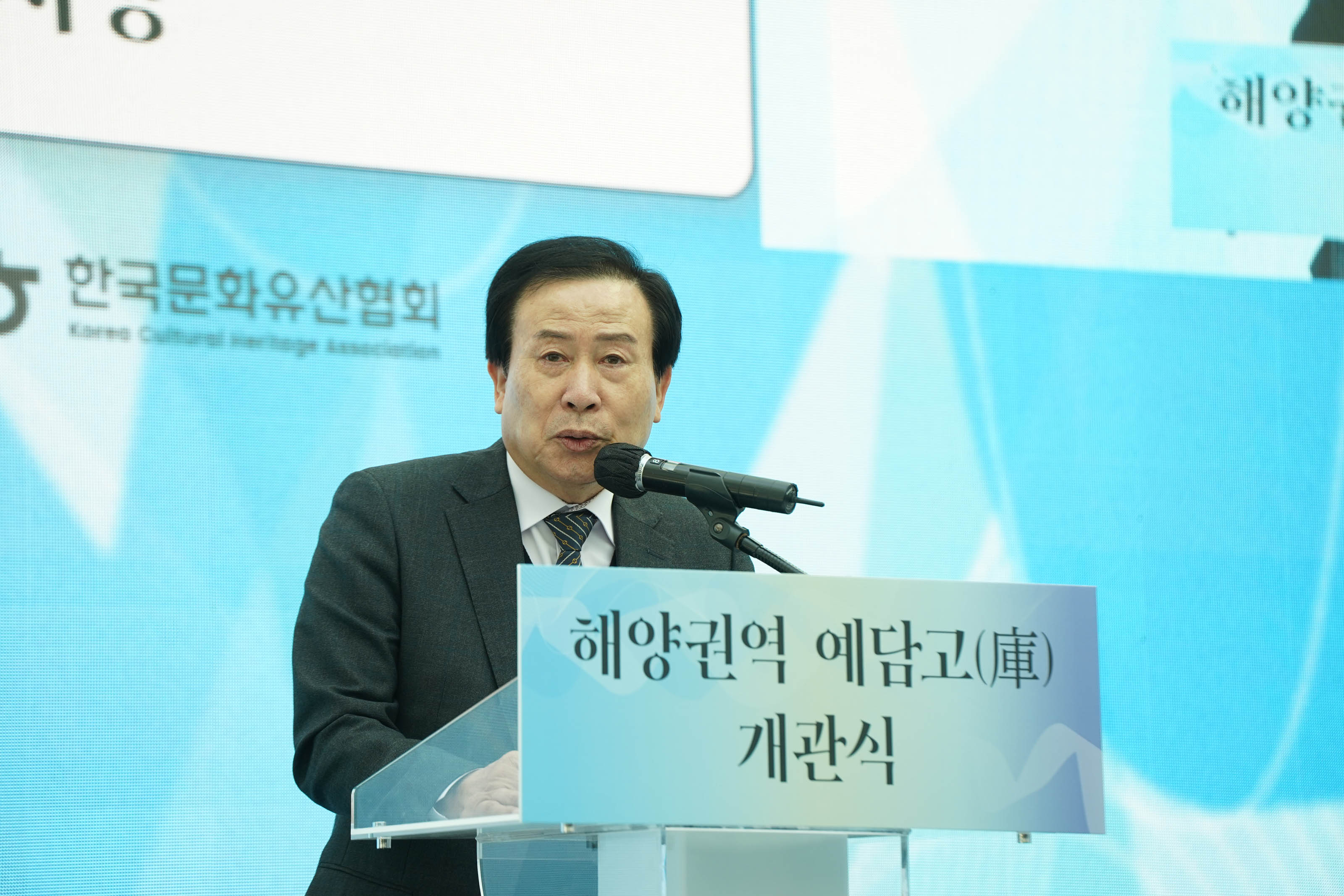 ‘해양권역 예담고(庫) 개관식’이라는 문구가 적힌 단상에서 박홍률 목포시장이 축사를 하고 있는 모습. 배경에는 ‘한국문화유산협회’ 로고와 명칭이 보이며, 행사 현장을 나타내는 파란색 톤의 디자인이 전체를 감싸고 있다.