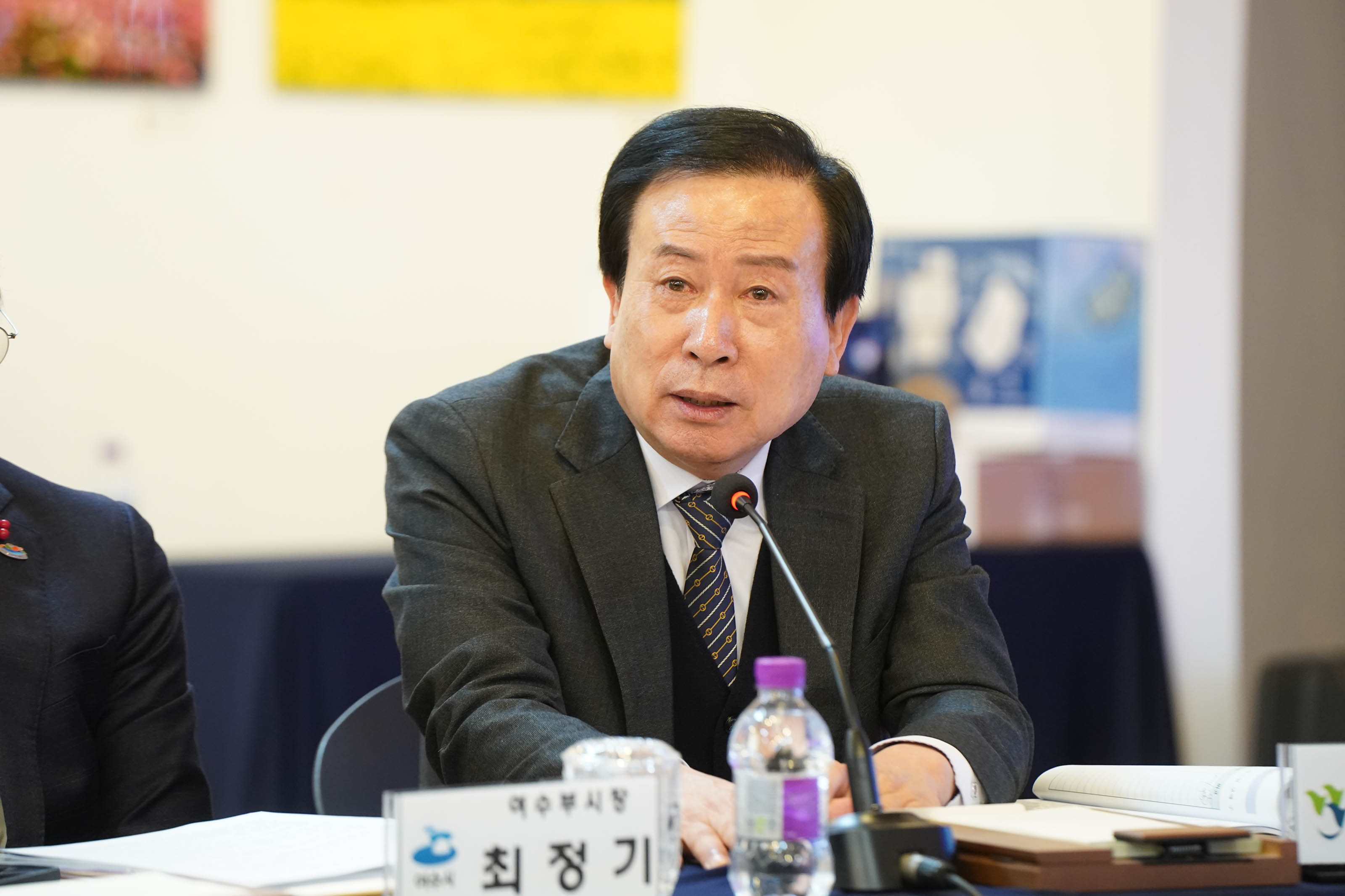 박홍률 시장이 마이크 앞에 앉아 전남시장군수협의회 정례회에서 발언하고 있는 모습. 정면을 응시하며 진지한 표정으로 회의에 임하고 있고, 앞에는 이름표와 생수병이 놓여 있다.