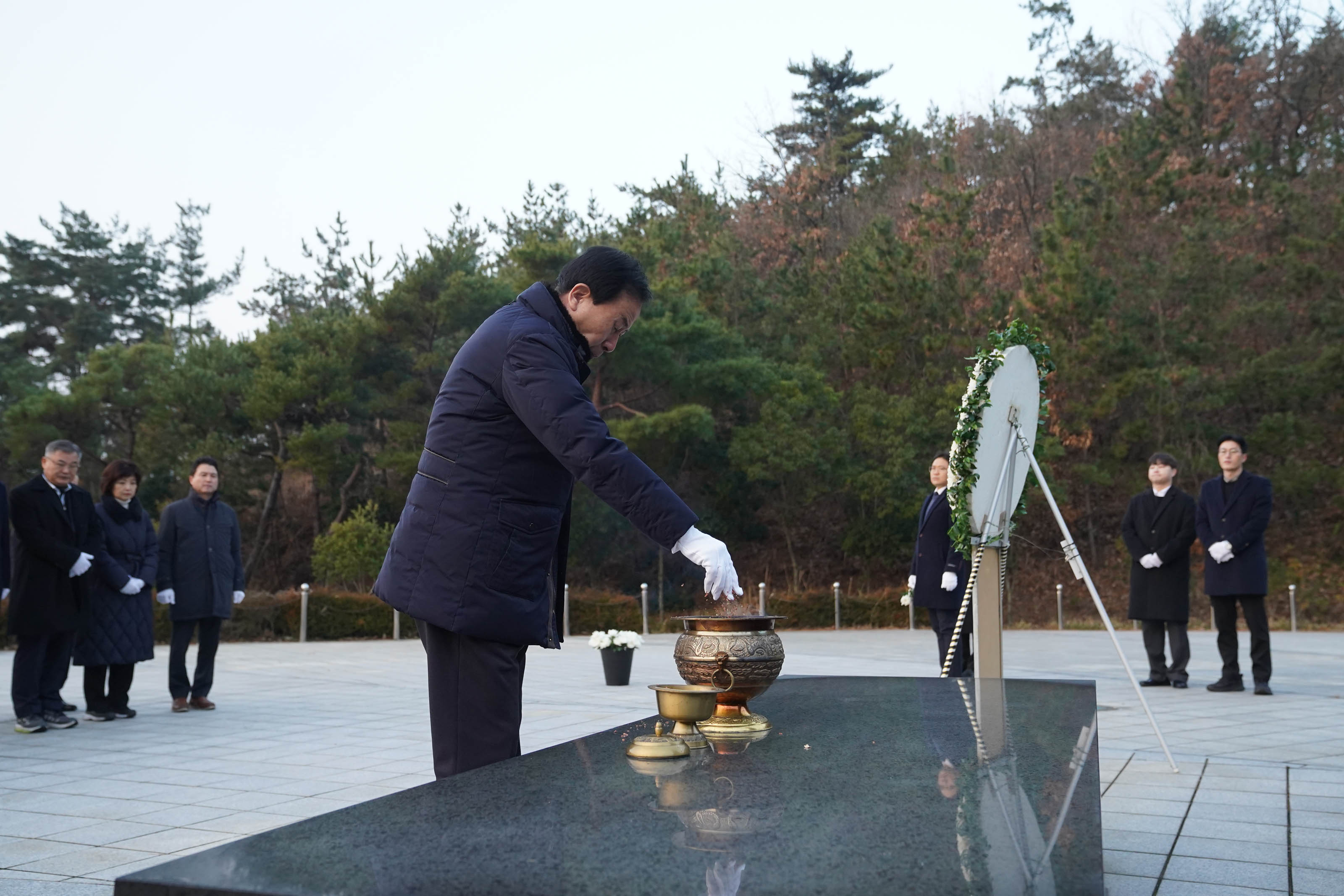 2025년 현충탑 새해맞이 참배 행사에서 박홍률 목포시장이 경의를 표하며 향을 올리고 있는 모습. 참배에 참석한 인사들이 뒤에서 이를 지켜보고 있는 모습이다.