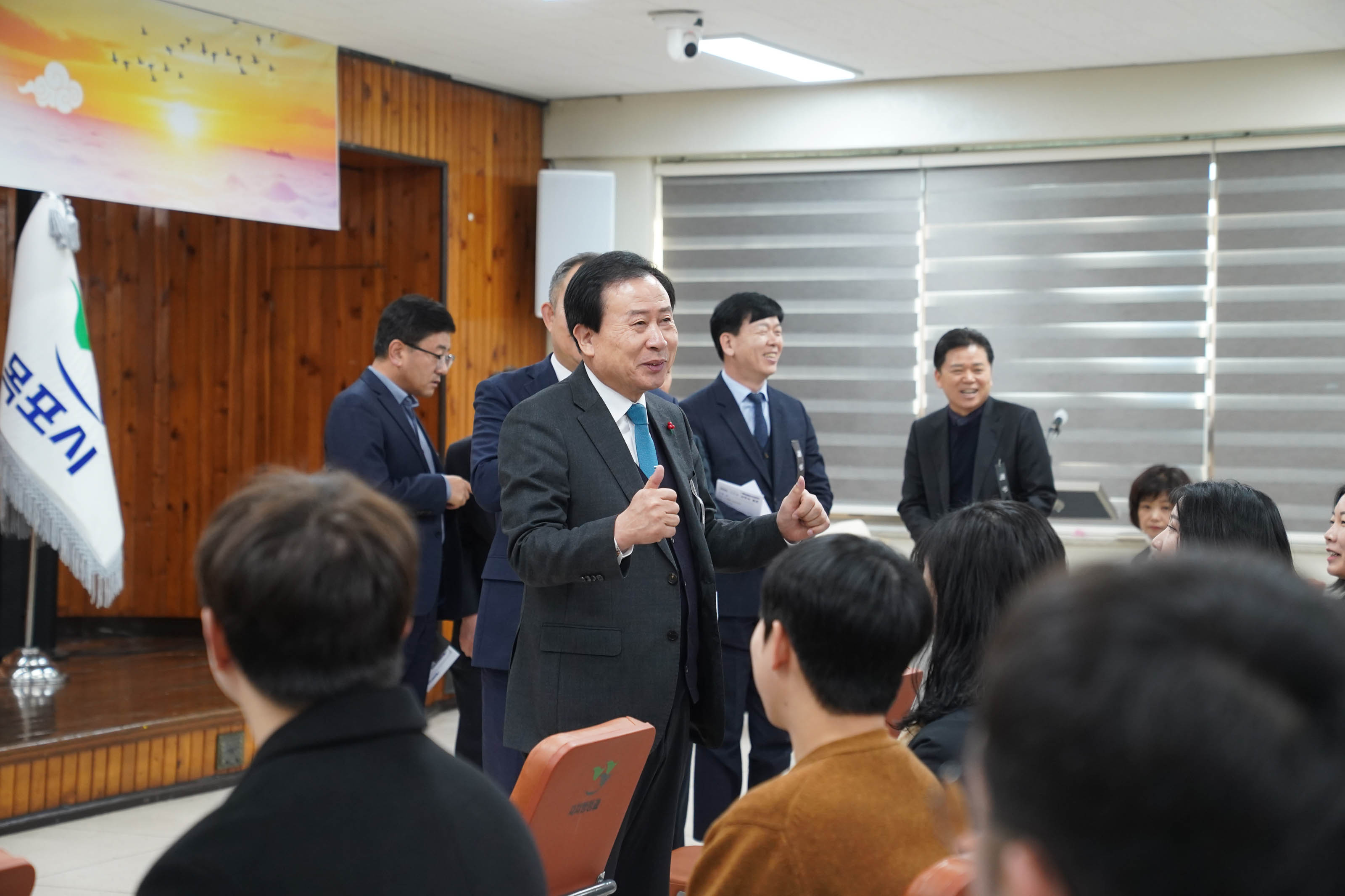 2025 을사년 시무식 후 박홍률 목포시장이 참석자들과 대화를 나누고 있는 모습. 뒤로는 몇몇 관계자들이 웃으며 이를 지켜보고 있다.