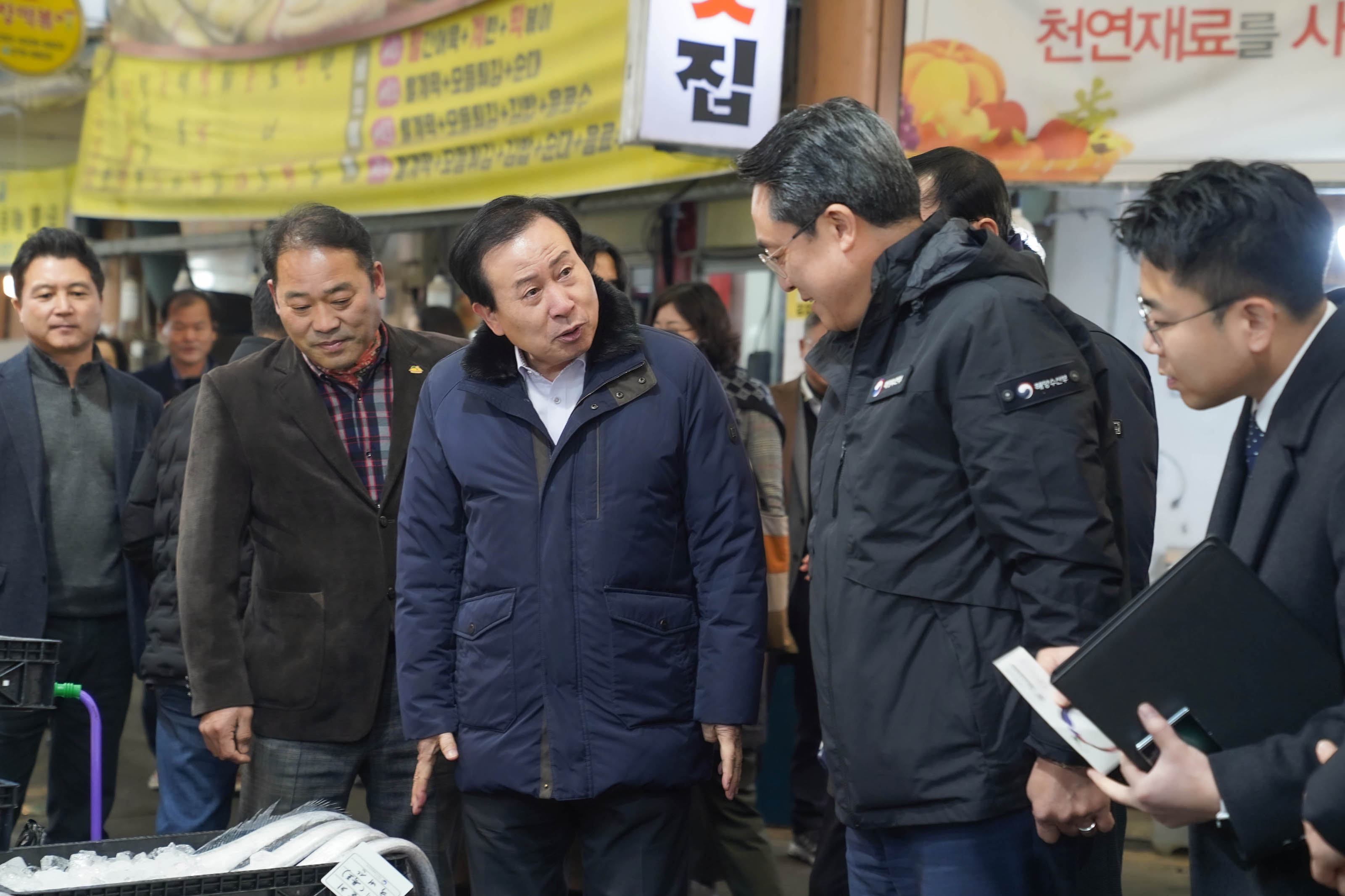 전통시장 통로에서 파란색 패딩을 입은 강도형 해수부장관과 박홍률 목포시장이 대화를 나누고 있다.