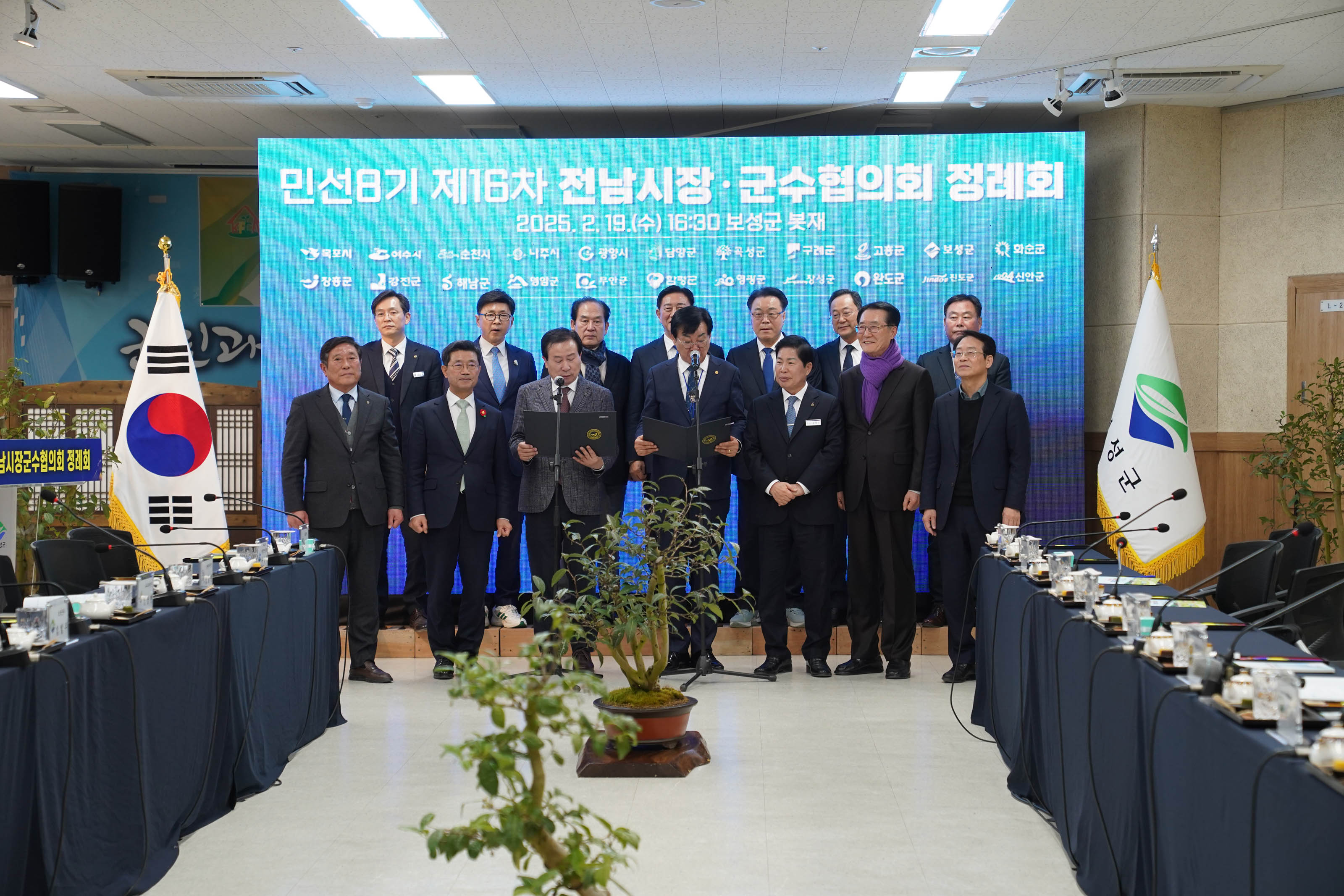 대형 LED 전광판 앞에서 전라남도 시장 및 군수들이 나란히 정렬되어 기념사진을 촬영하고 있는 모습. 화면 상단에 글자 민선8기 제16차 전남시장·군수협의회 정례회 2025.2.19(수) 16:30 보성군 봇재가 크게 보이며, 전남 각 시·군 이름들이 로고와 함께 나열되어 있음.