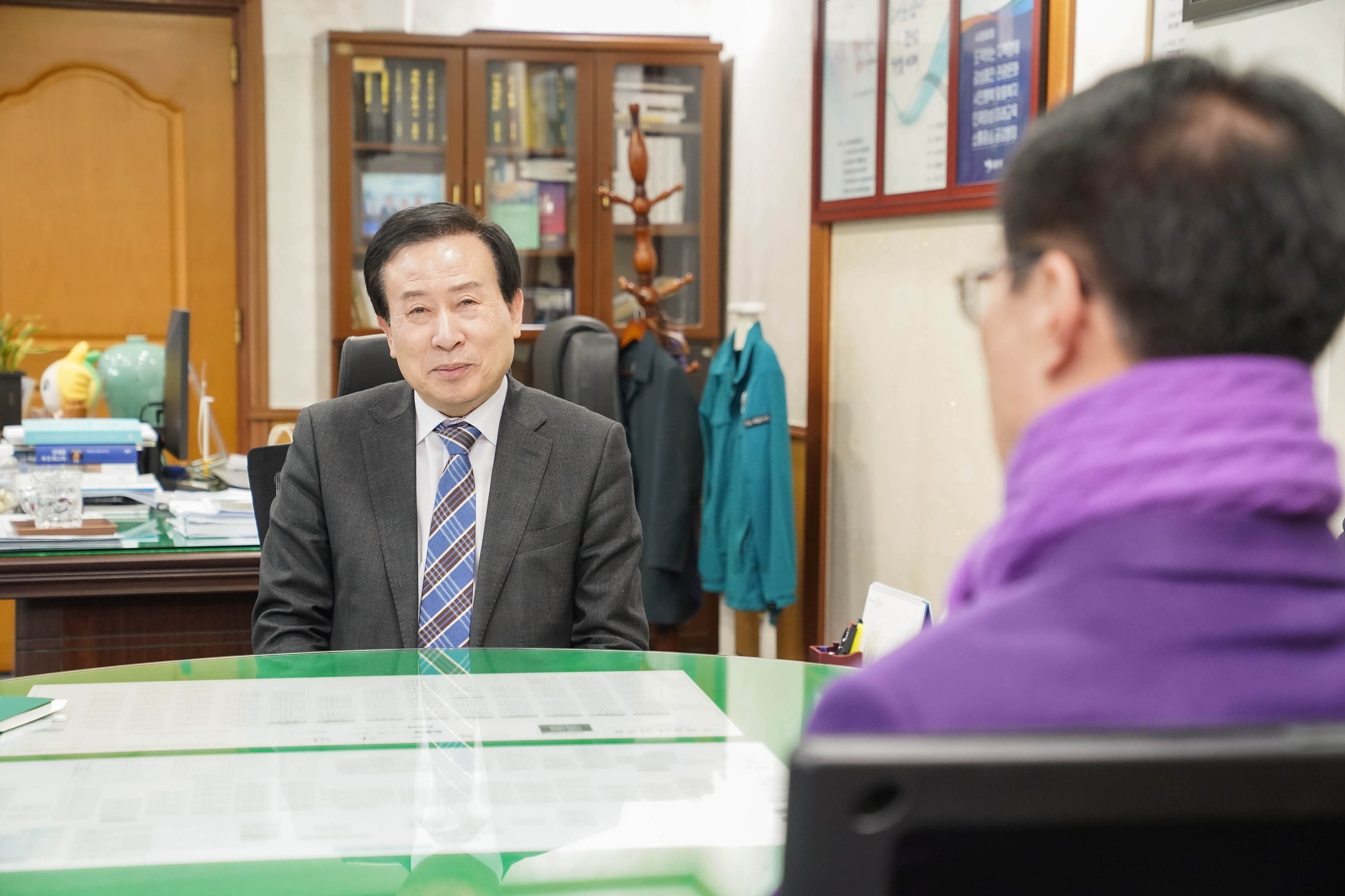 보라색 스카프와 재킷을 입은 관게자와 그 앞에 앉은 박홍률 목포시장의 모습. 뒷배경에는 책장이 보이며, 책장에는 다양한 서적들이 정리되어 있다.