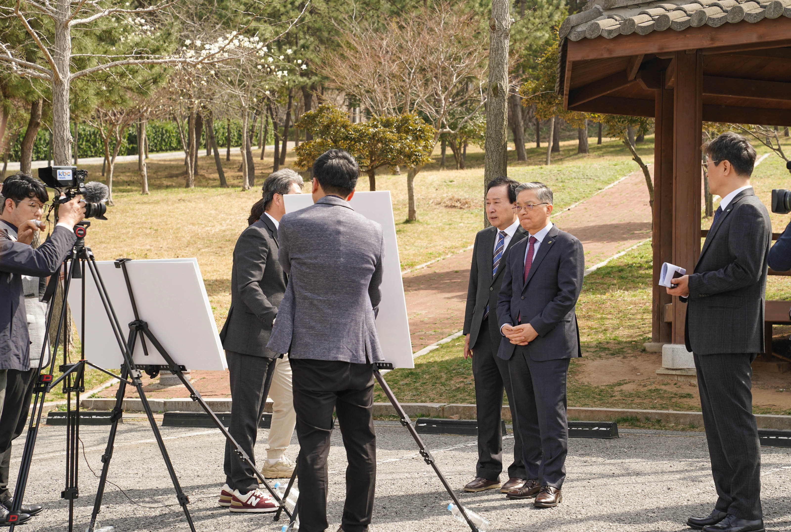 야외 공원에서 삼각대와 화이트보드를 앞에 두고 다수의 사람들이 브리핑을 받고 있다. 가운데 양복을 입은 박홍률 목포시장과 이한준 한국토지주택공사 사장이 주의 깊게 설명을 듣고 있다.