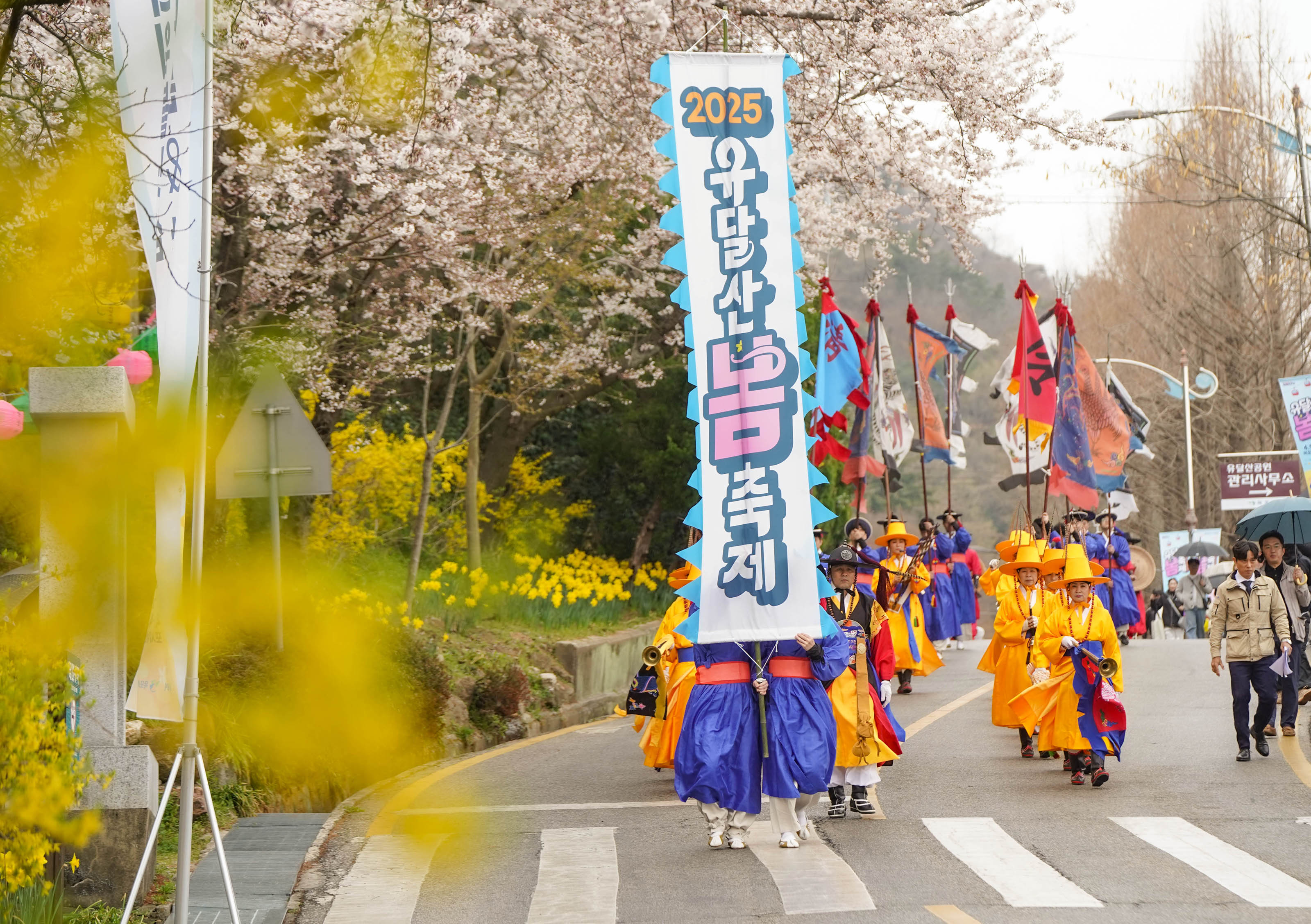 전통복장을 입은 행사관계자들이 '2025 유달산봄축제' 현수막을 들고 거리를 행보하는 모습