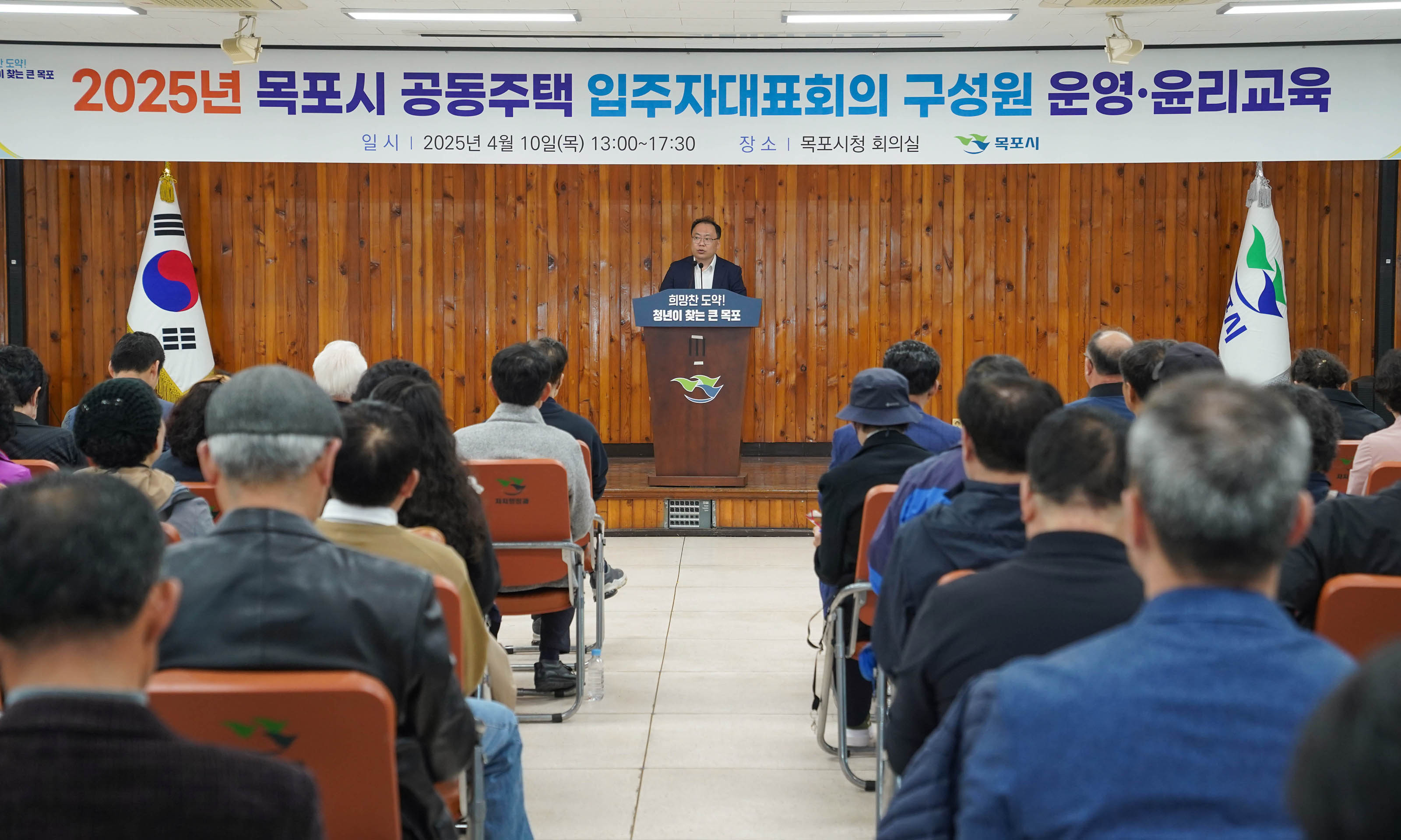 '2025년 목포시 공동주택 입주자대표회의 구성원 운영·윤리교육
일시 | 2025년 4월 10일(목) 13:00~17:30
장소 | 목포시청 회의실
목포시' 문구가 적혀있는 현수막이 걸려있는 강당에서 
'희망찬 도약!
청년이 찾는 큰 목포' 문구가 적힌 강연대에서 서서 발표하는 발표자와 발표를 듣는 사람들의 모습