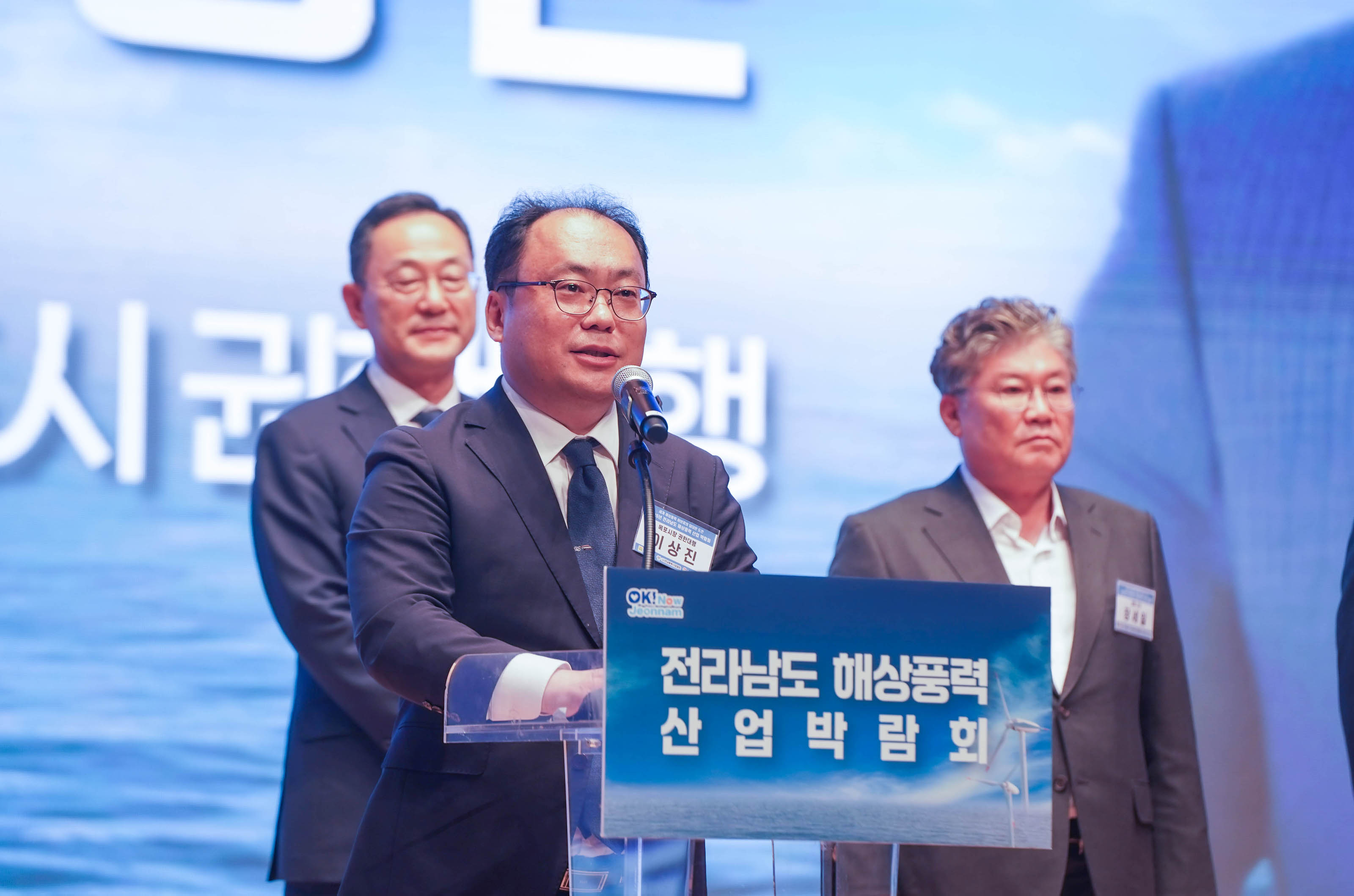 '전라남도 해상풍력 산업 박람회' 로고가 부착된 연단에서 이상진 목포시 권한대행이 마이크를 잡고 발언하는 근접 사진.