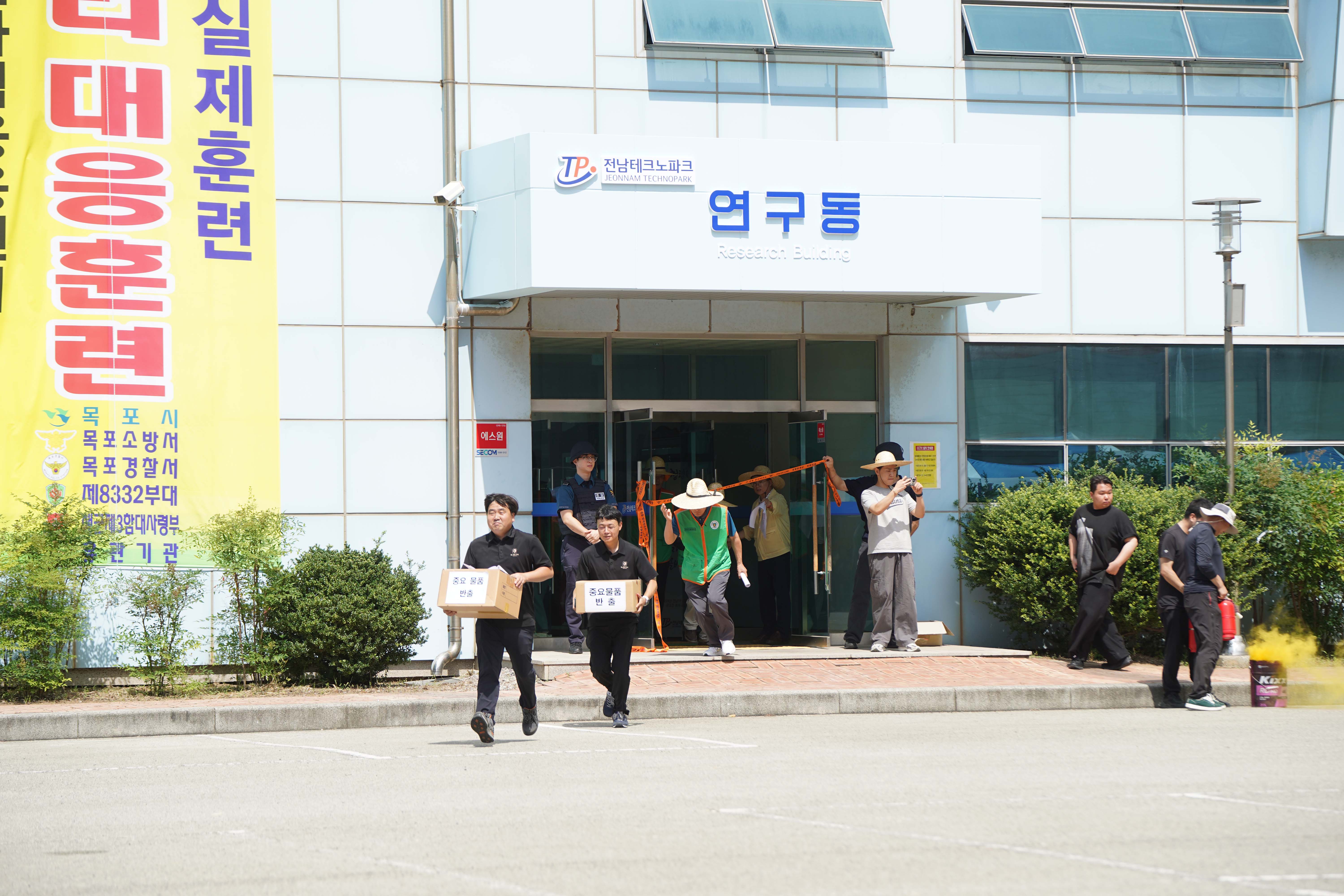 전남테크노파크 연구동 입구에서 '중요물품 반출'이라고 적힌 상자를 들고 긴급히 대피하는 관계자들의 모습.