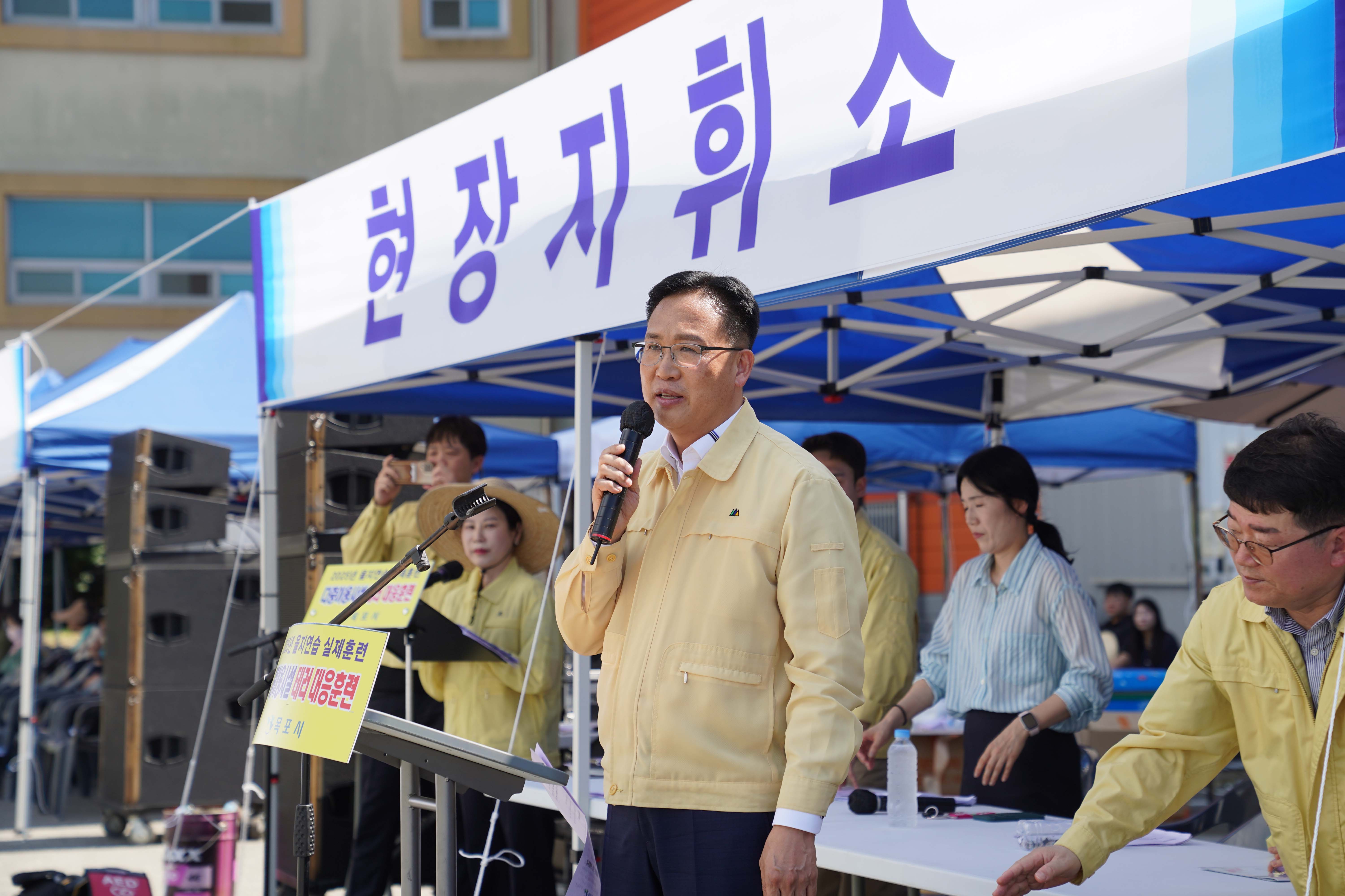 '현장지휘소' 단상에서 마이크를 잡고 훈련 강평이나 지시 사항을 전달 중인 지휘관의 모습.