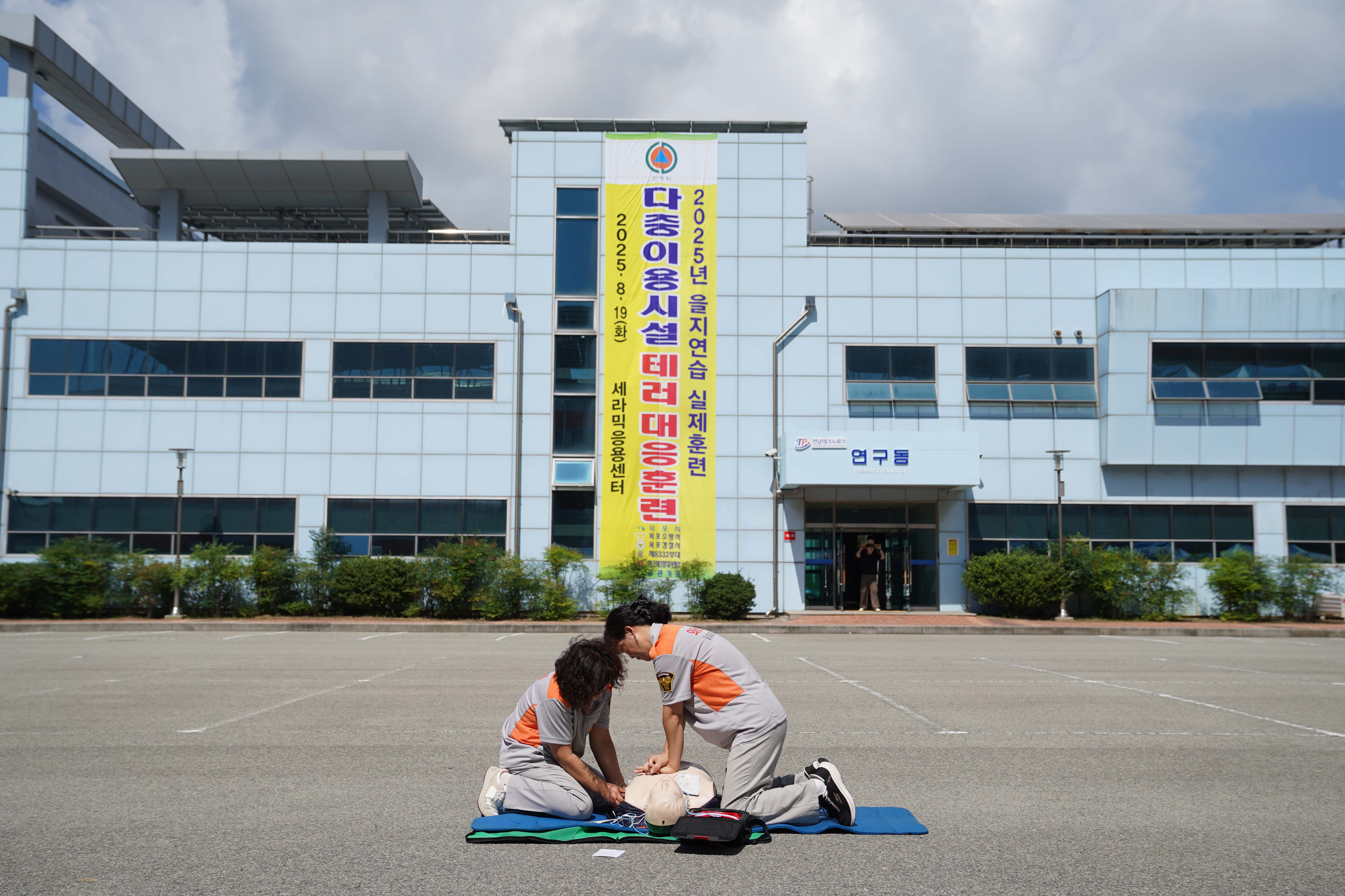 을지연습 훈련중 바닥에 놓인 마네킹으로 심폐소생술을 하고 있는 두 여성의 모습.
