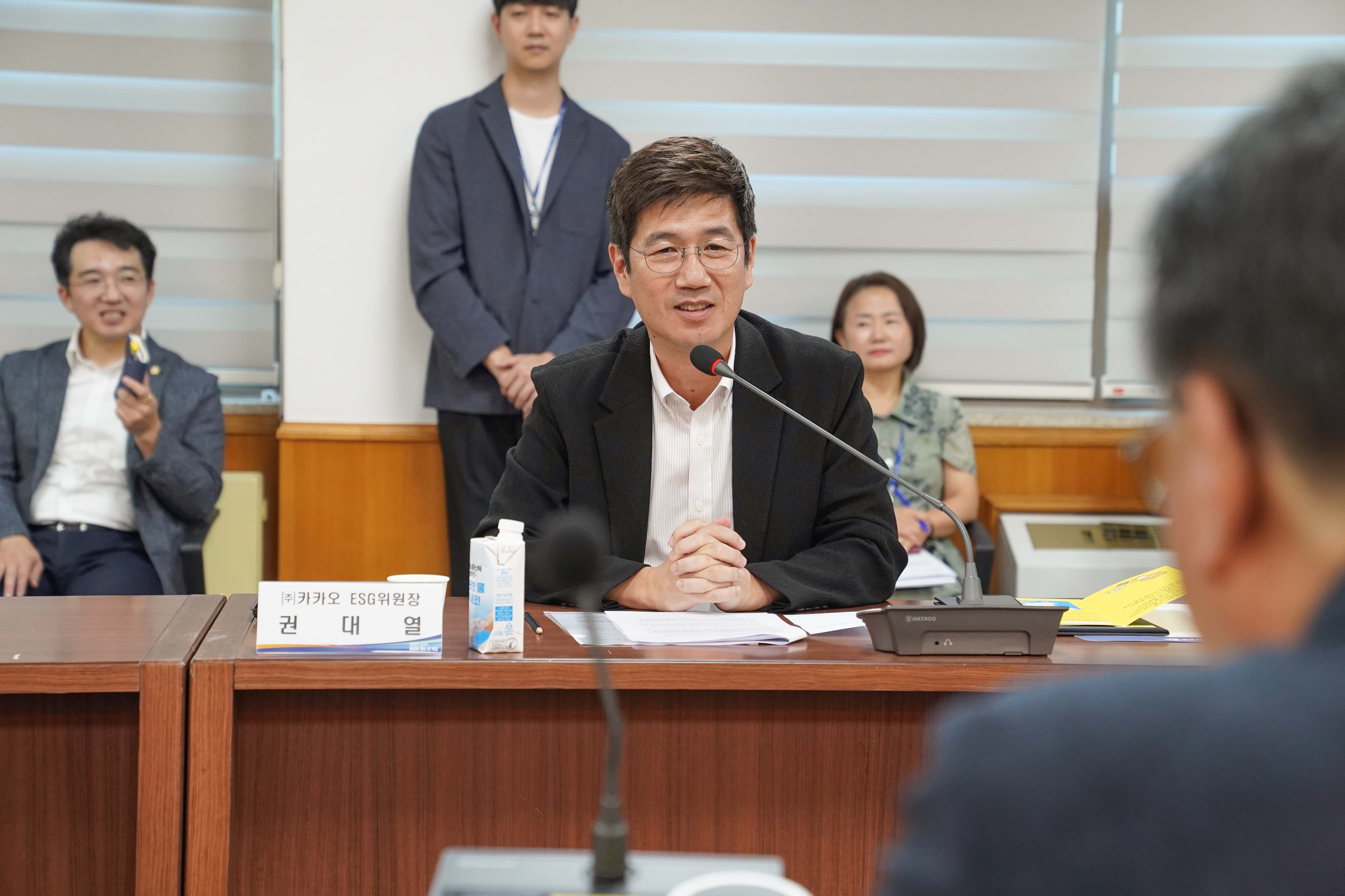 '(주)카카오 ESG 위원장 권대열'이라는 명패가 놓인 자리에서 권대열 위원장이 마이크 앞에서 발언하고 있는 모습.