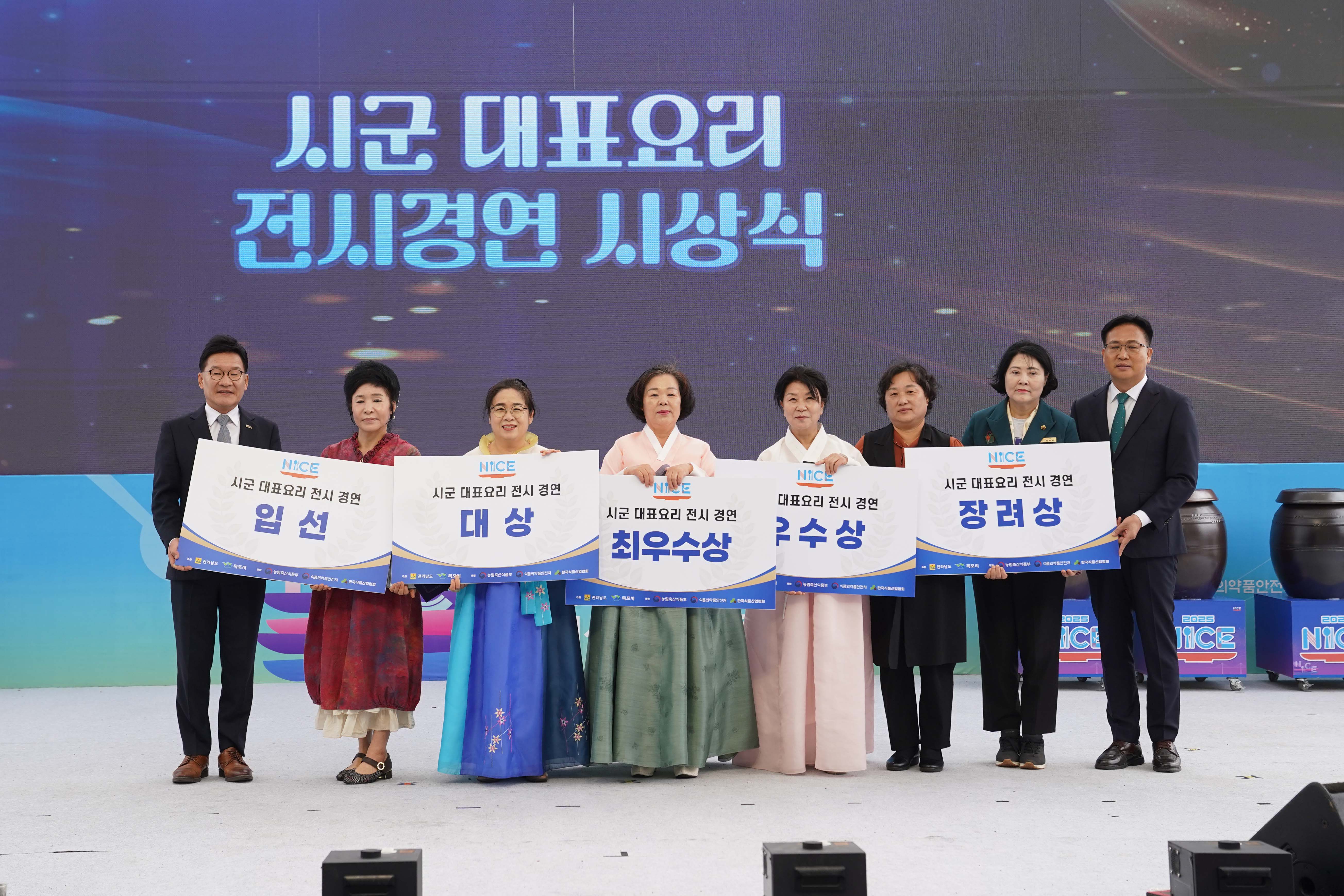 '시군 대표요리 전시경연 시상식' 무대에서 수상자들이 상장을 들고 기념 촬영을 하는 모습. 왼쪽부터 김원이 국회의원, 임선(상장), 대상, 최우수상, 우수상, 장려상(상장), 조석훈 목포시장 권한대행이 함께 서 있음.